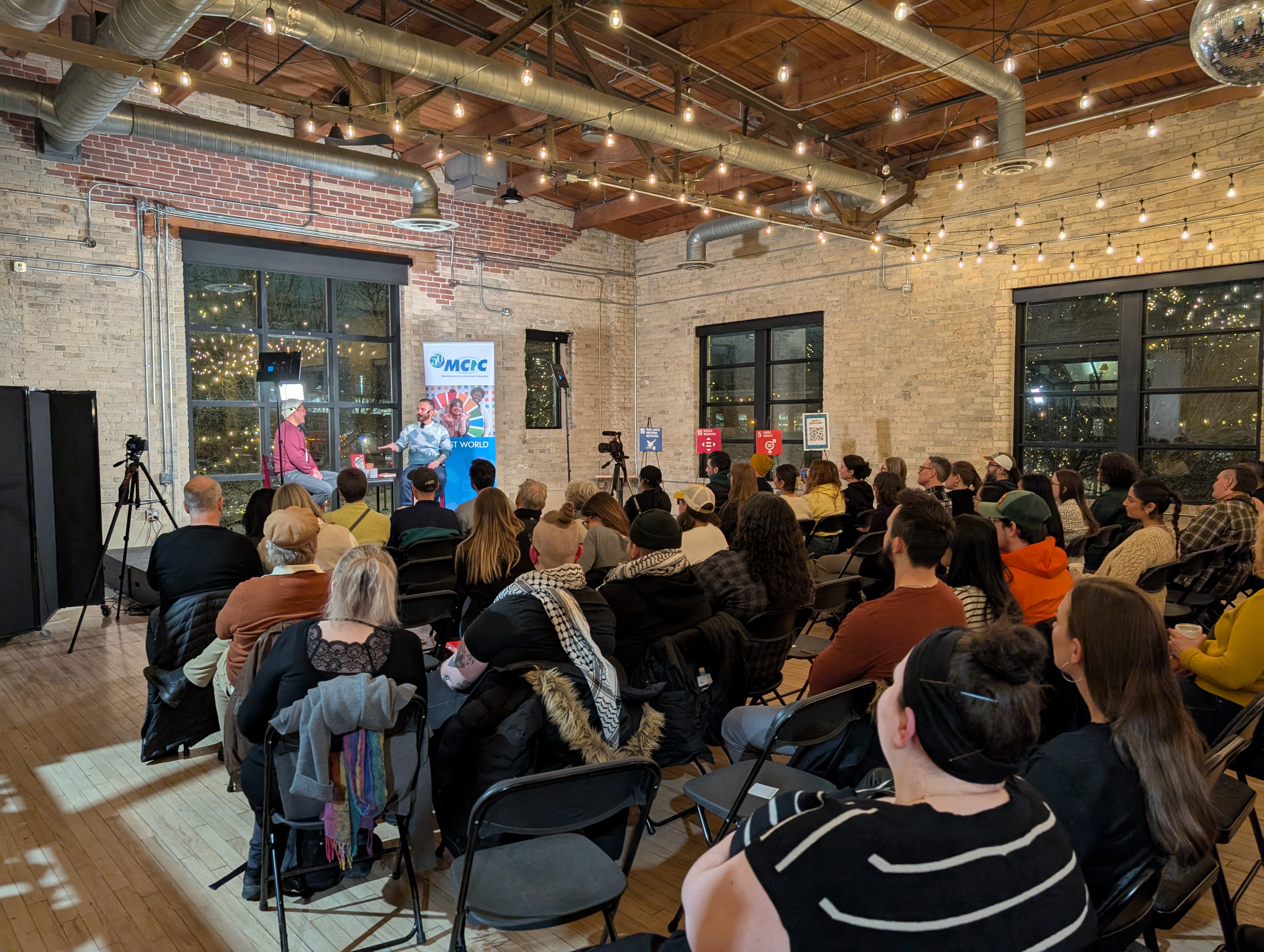 Danny and Faith chat on stage in front of a large group.